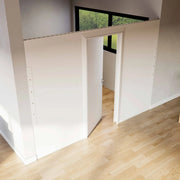 A Modular partition wall room divider with a swing door closing off a space seen from an angle with the door open